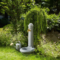Fontaine robinet extérieur effet pierre dans un jardin