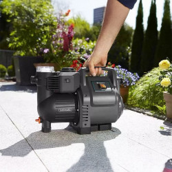 Utilisation pratique de la pompe Gardena 3500/4 avec poignée ergonomique pour une mobilité facile sur une terrasse de jardin.