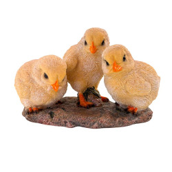 Trois poussins jaunes en figurine réaliste, positionnés côte à côte sur un socle texturé, avec détails fins du plumage et des be
