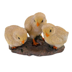 Vue frontale légèrement en plongée de la figurine de trois poussins jaunes de 19 cm, sur un socle marron à texture rocheuse.