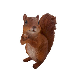 Figurine d’un écureuil brun tenant une noisette entre ses pattes, debout avec une grande queue en panache.