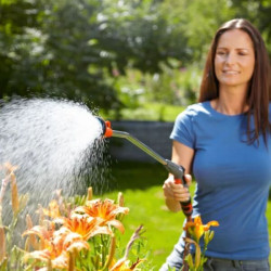 Femme utilisant une lance d'arrosage Gardena pour arroser des fleurs