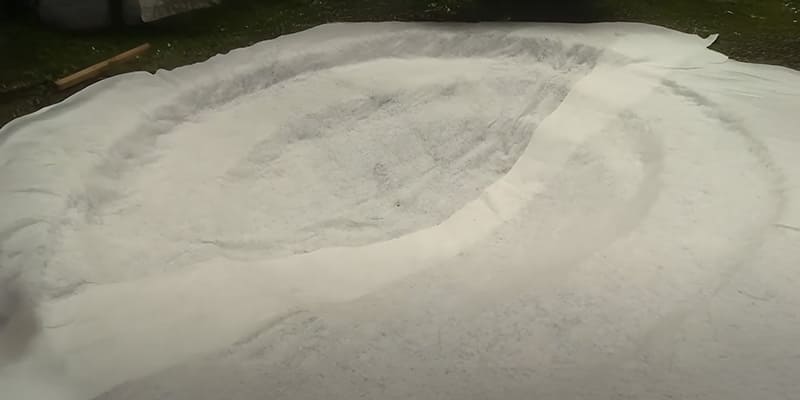 Pose du feutre géotextile sur le fond du bassin pour protéger la bâche