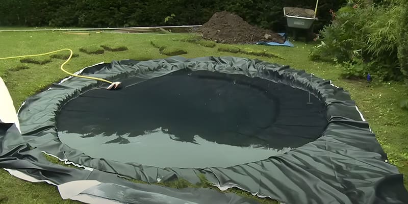 Remplissage du bassin et ajustement de la bâche avant fixation des bords