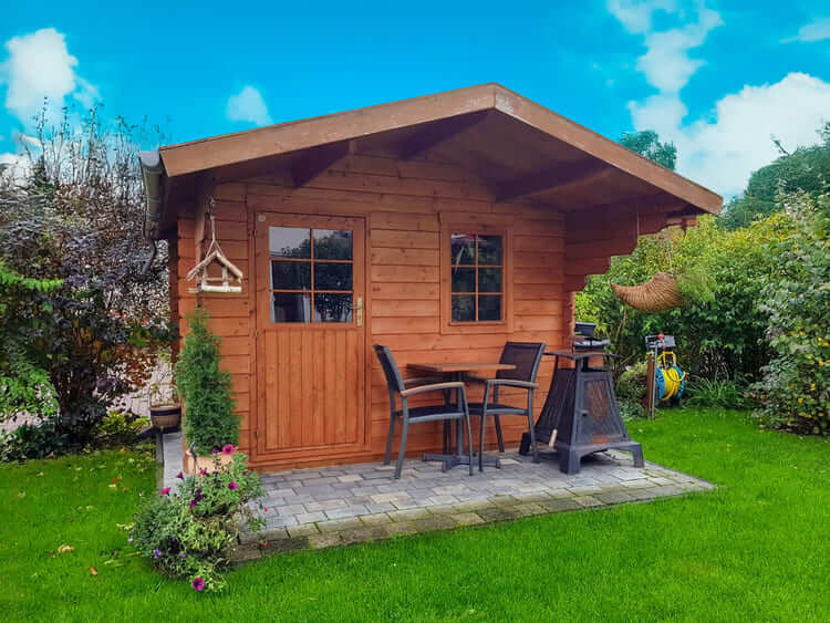 Petit abri de jardin en bois de pin avec terrasse aménagée et remise à outils