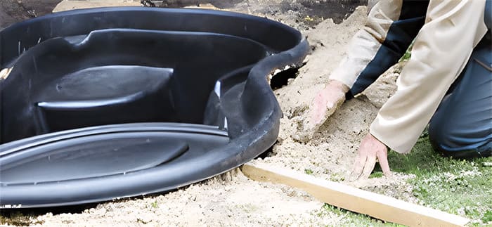 Remblayage du bassin de jardin avec du sable pour stabilisation